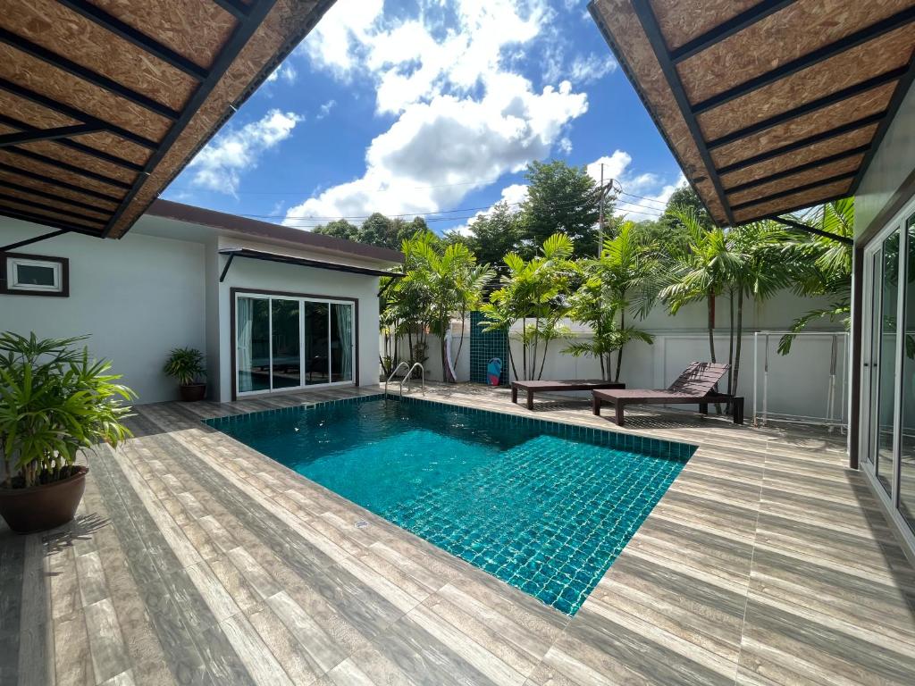 a swimming pool in a house with a wooden deck at 拉威查龙山顶大佛三卧泳池别墅Thaiya Villa in Ban Klang