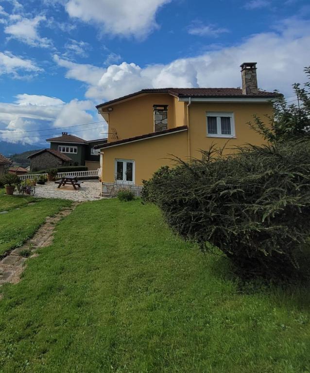 a yellow house with a bench in a yard at La Tablada in Recuevo