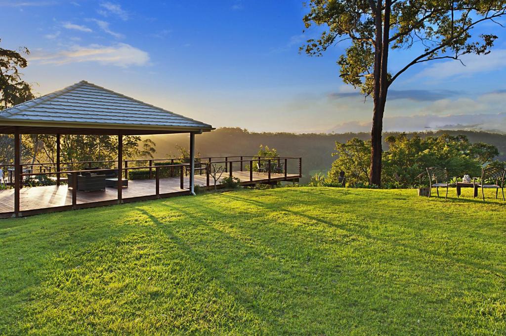 a gazebo with a bench on a grass field at Escarpment Retreat & Day Spa for Couples in Mount Tamborine