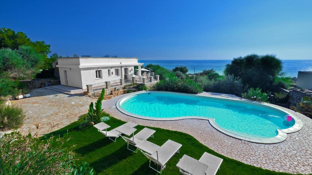 una piscina con sillas y una casa en Villa Opunzie Torre Vado, en Torre Vado