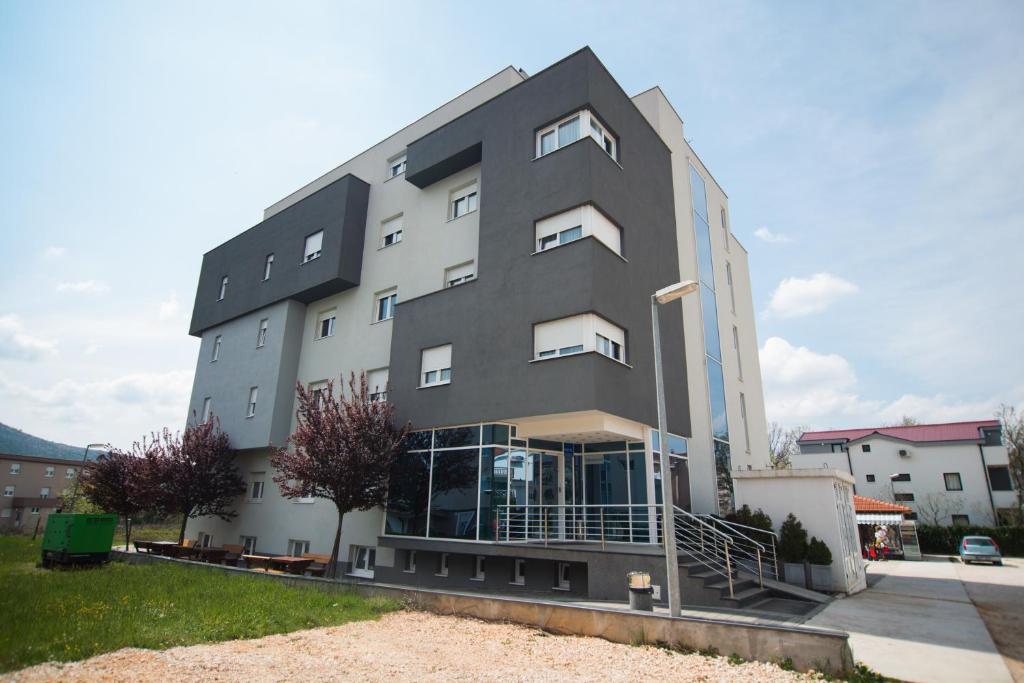 um grande edifício cinzento com janelas do lado em Hotel Lux em Medjugorje