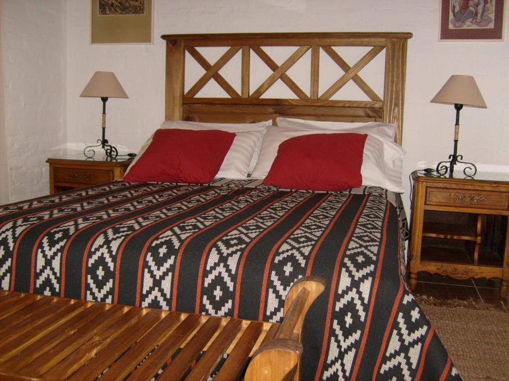 a bedroom with a large bed with red pillows at CABAÑAS AGUA DEL MEDIO in Las Heras