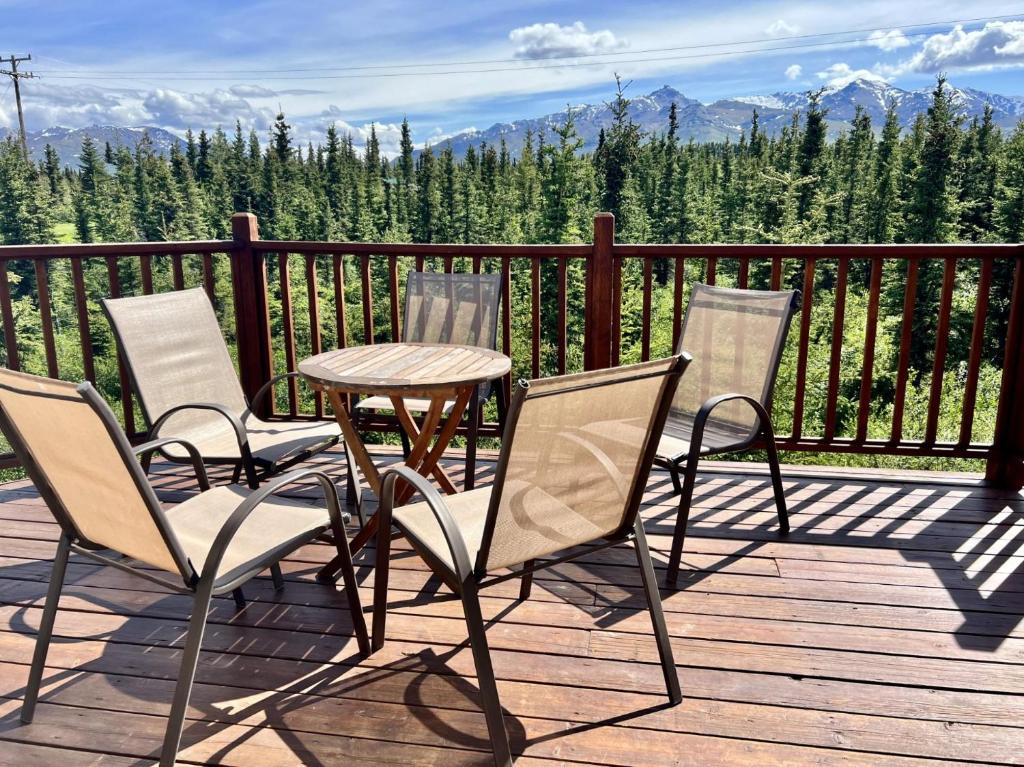 una mesa y 4 sillas en una terraza con vistas en 5 Star Denali Park Spacious Family Home, en Healy