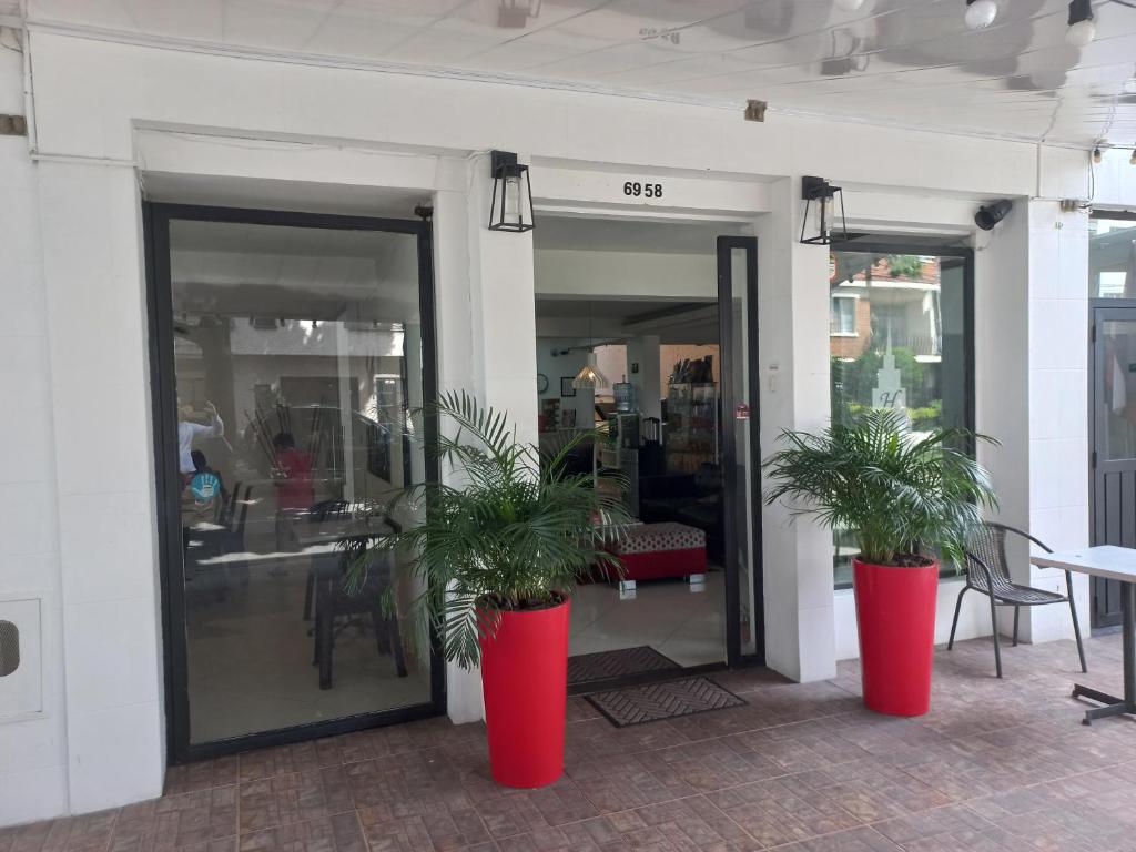 two plants in red containers in front of a store at Hotel Quinta Avenida in Medellín