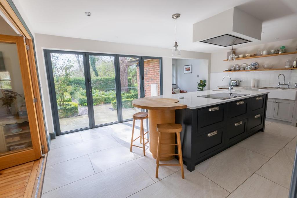 a kitchen with a island with a sink and a counter at Modernised seven bedroom country house and garden with hot tub in Cranbrook