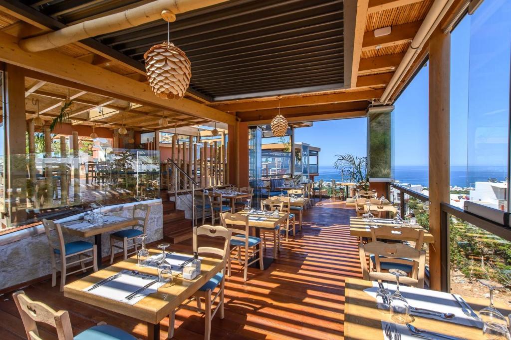 a restaurant with tables and chairs and a view of the ocean at Esperides Resort Crete, The Authentic Experience in Hersonissos
