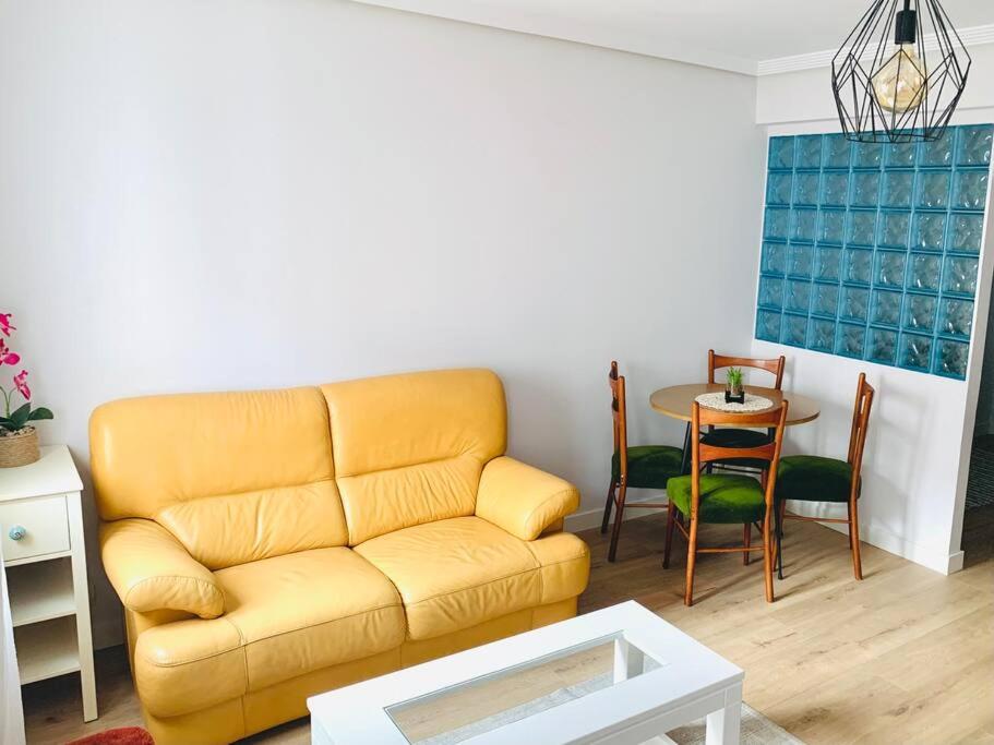 a living room with a yellow couch and a table at Apartamento Ruiz Zorrilla in Santander