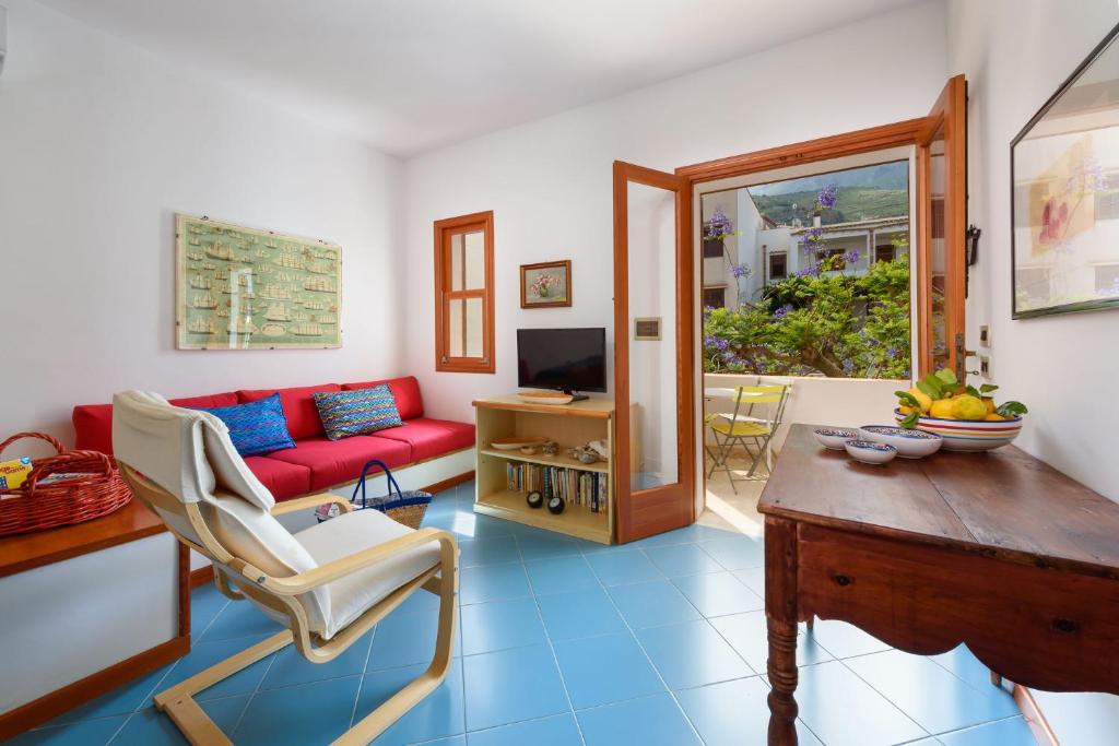 - un salon avec un canapé rouge et un sol bleu dans l'établissement Casa ChiaraMarina, à Macari