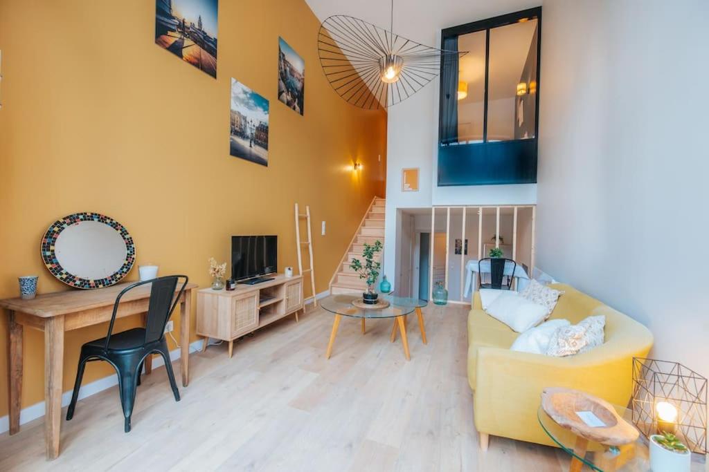 ein Wohnzimmer mit einem gelben Sofa und einem Tisch in der Unterkunft Vieux Lille Village Cottage in Lille