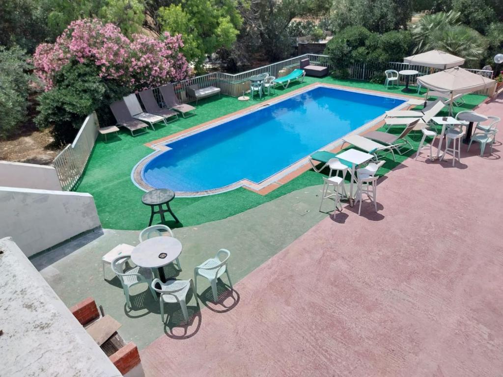 an overhead view of a swimming pool with tables and chairs at Whitestar Guesthouse in Salina