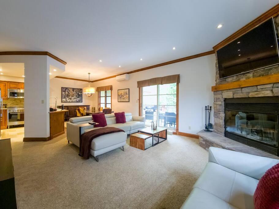 a living room with a couch and a fireplace at Plateau 202-5/STUNNING 3bdr with POOL in Mont-Tremblant