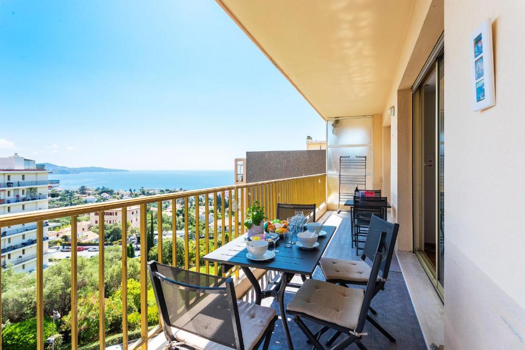 un balcon avec une table et des chaises et l'océan dans l'établissement GRAND SOLEIL AP4365 By Riviera Holiday Homes, à Nice