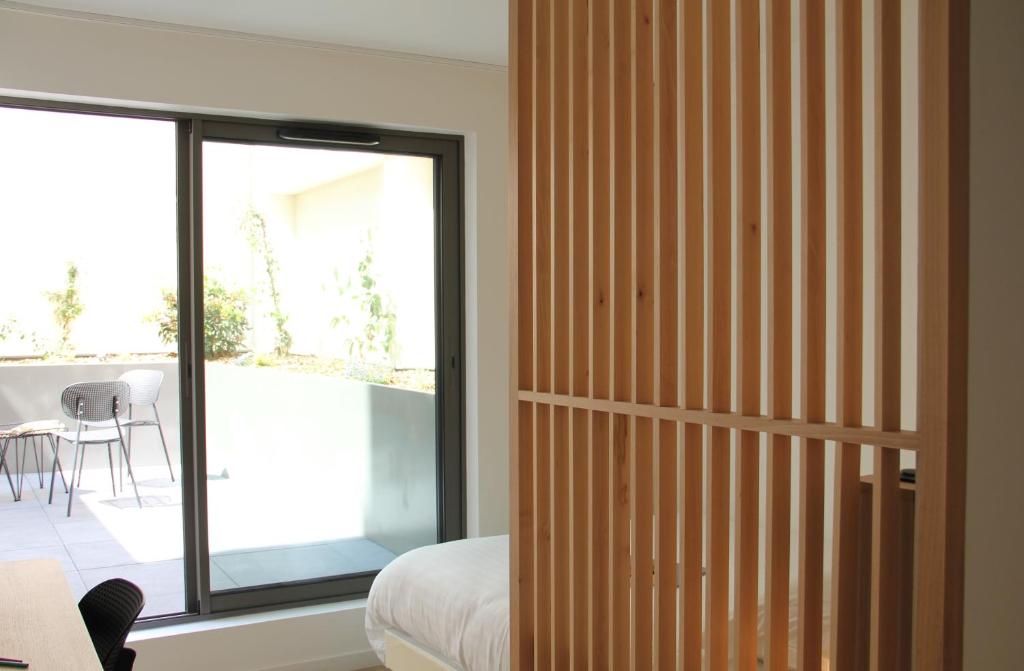 a bedroom with a sliding glass door to a patio at FINESTATE Coliving Champs-Elysées in Paris