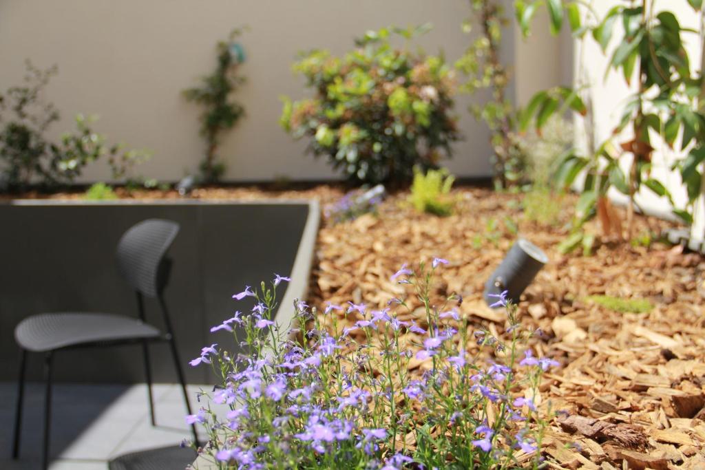a garden with purple flowers and a table and a chair at FINESTATE Coliving Champs-Elysées in Paris