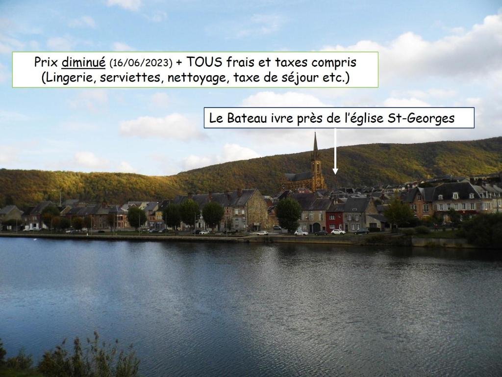 a picture of a river with a town in the background at Le bateau ivre in Fumay