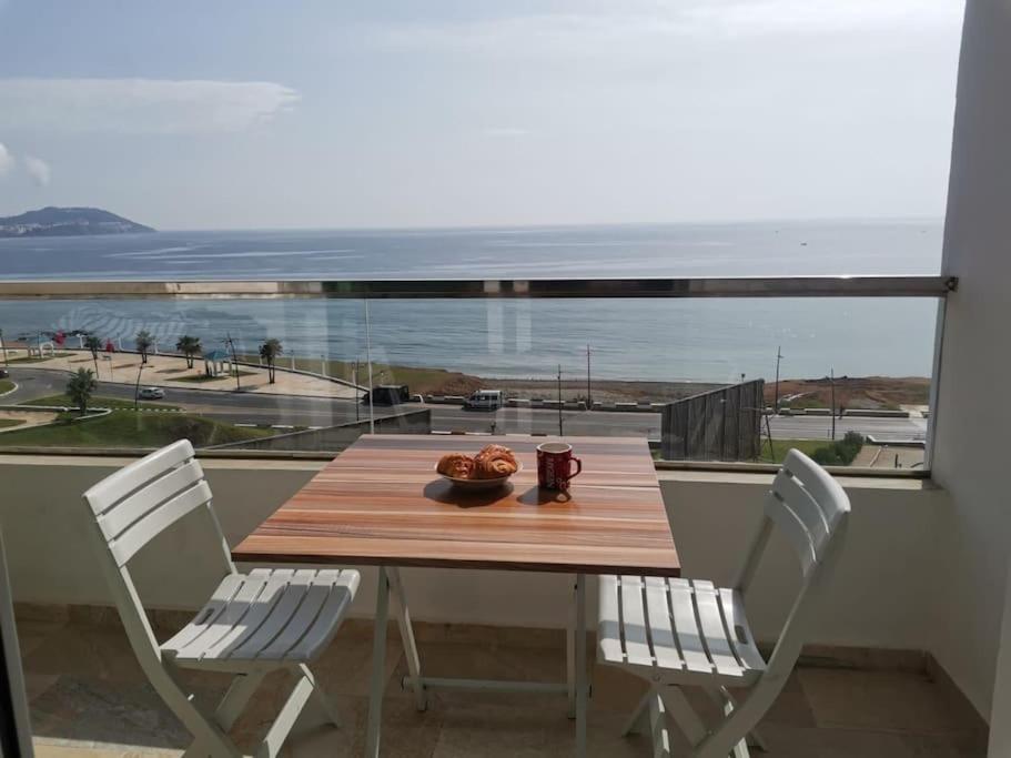 una mesa y sillas con vistas al océano en AppartF3 vue panoramique sur mer, en Fnidek