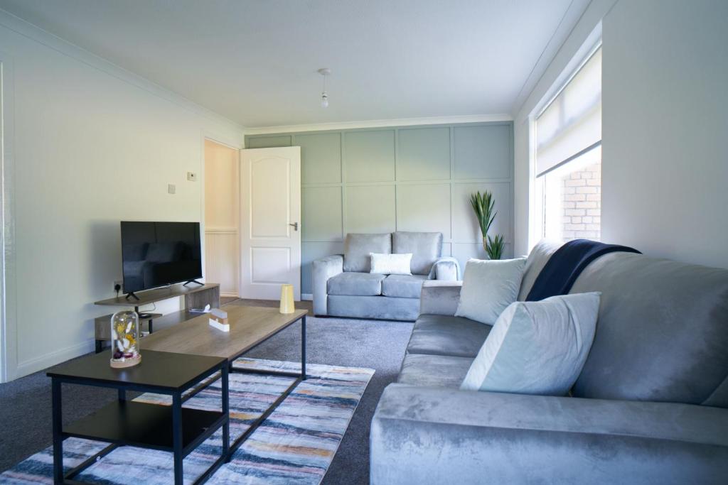 a living room with a couch and a table at Terrace Apartment in Airdrie