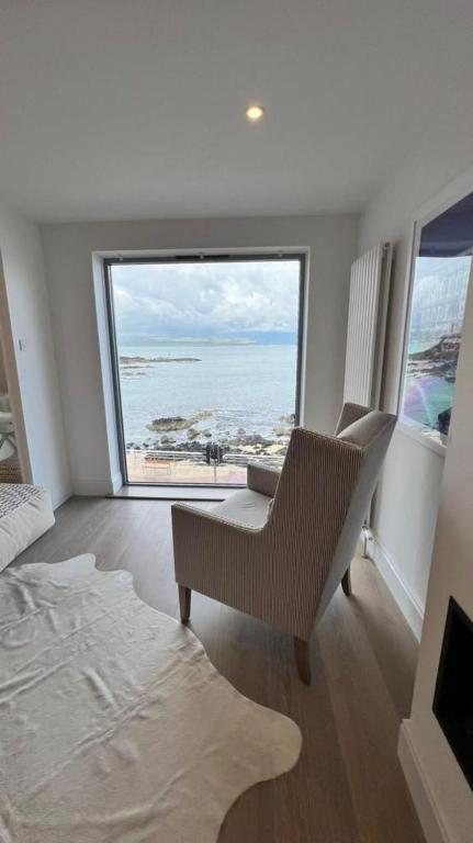 a bedroom with a bed and a view of the ocean at Morelli Plaza Portstewart in Portstewart