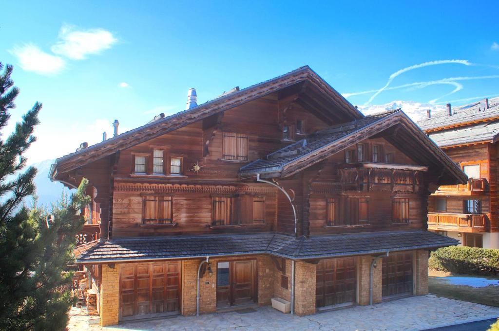 a large wooden house with wooden doors at Chalet à Crans-Montana 17 personnes in Crans-Montana