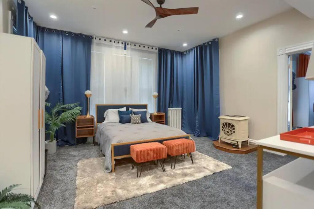 een slaapkamer met blauwe gordijnen en een bed met 2 stoelen bij Charming Downtown Retreat Steps from Capitol Bldg in Harrisburg