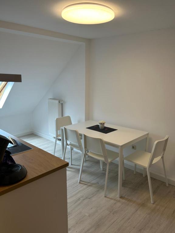 una sala da pranzo con tavolo e sedie bianchi di Apartment Ferien Wohnung 4 a Gera