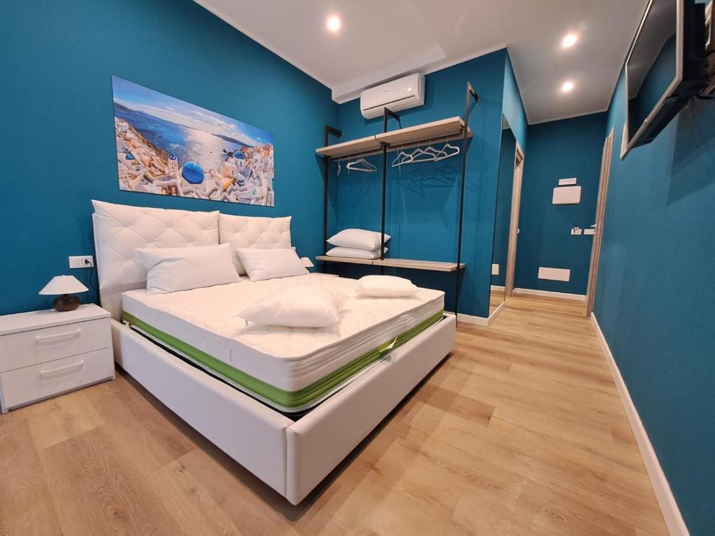 ein Schlafzimmer mit einem großen weißen Bett mit blauen Wänden in der Unterkunft Relais di gusto in La Spezia