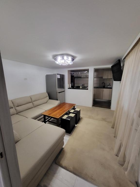 ein Wohnzimmer mit einem Sofa und einem Tisch in der Unterkunft Casa Laura&Florin in Constanţa