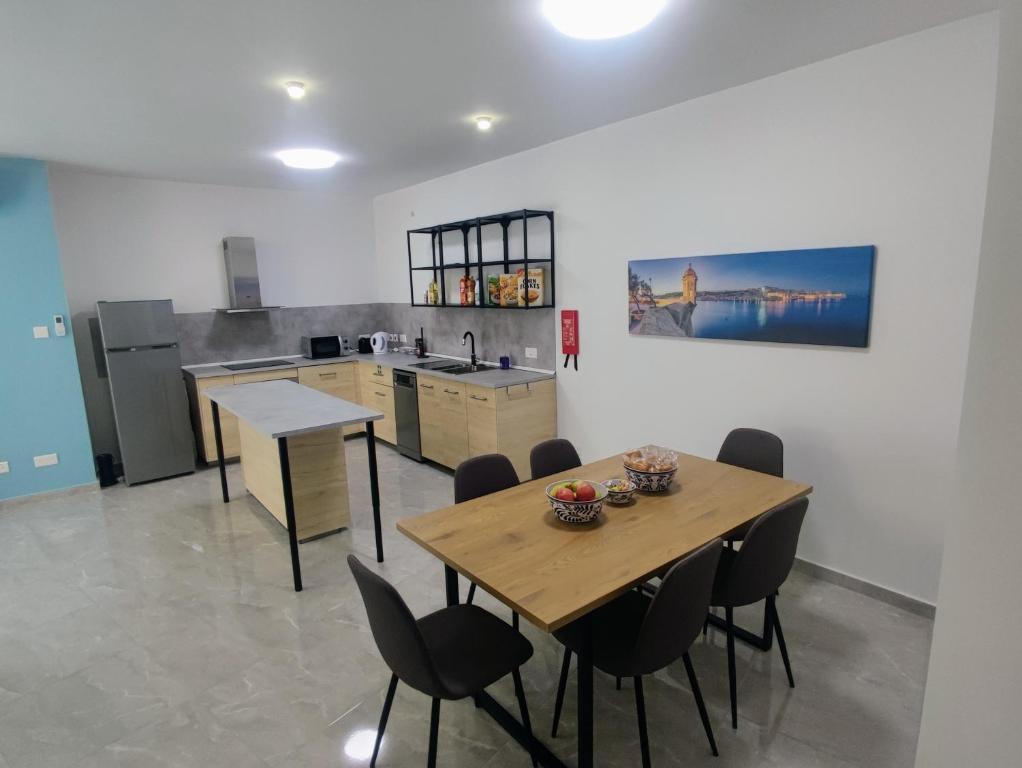 cocina con mesa de madera y sillas en Deggies Apartments - spacious, modern apartment!, en Naxxar