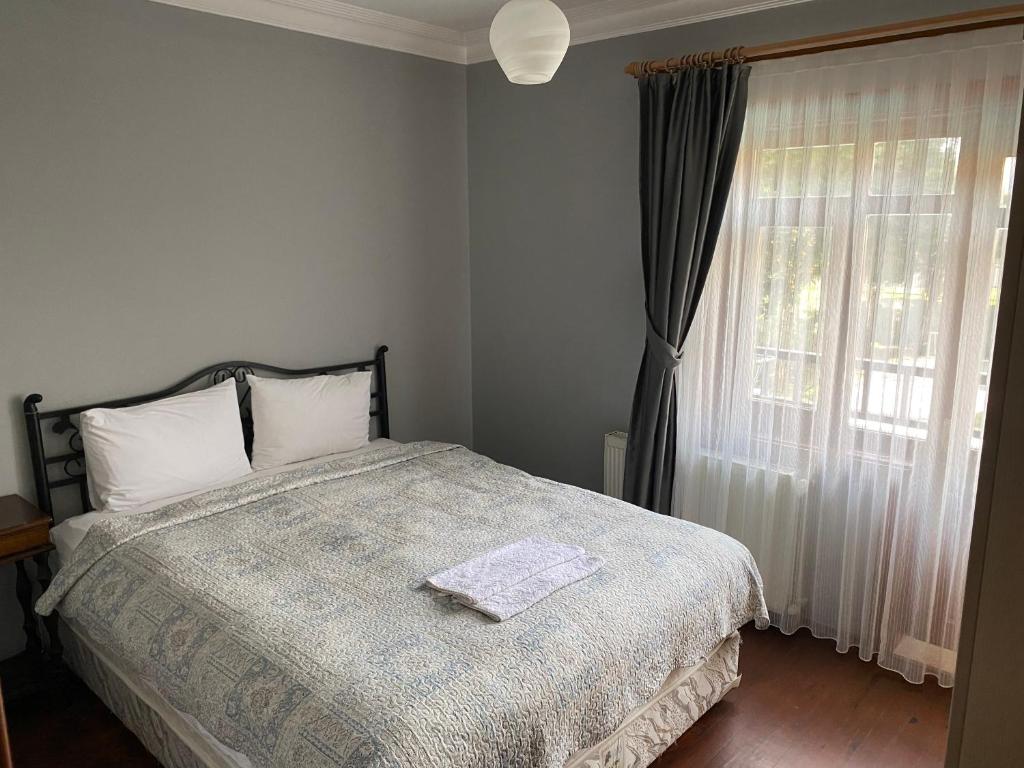 a bedroom with a bed and a window at Four seanson müstakil sıcak havuzlu villa in Sapanca