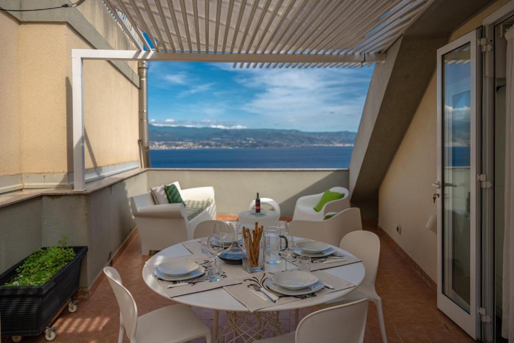 a table and chairs on a balcony with a view of the ocean at Amarea in Messina