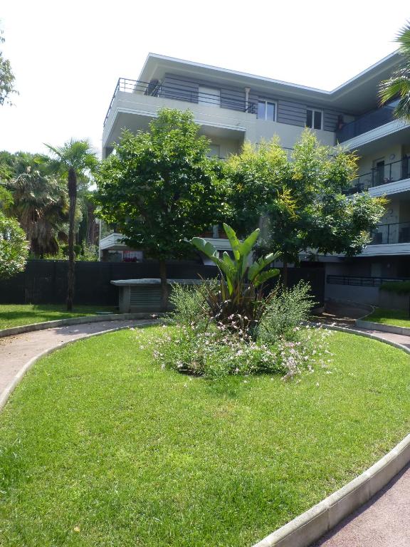 un jardin devant un immeuble dans l'établissement BEAU SOLEIL, à Mandelieu-la-Napoule