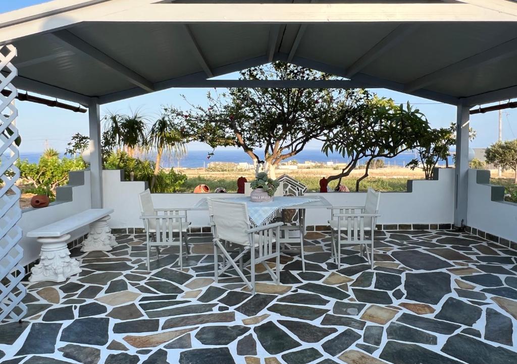 d'une terrasse avec une table et des chaises sur un sol en mosaïque. dans l'établissement Afiartis Avli House, à Karpathos