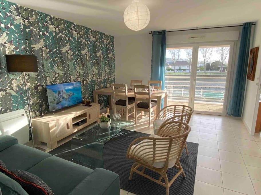 un salon avec un canapé bleu et une table dans l'établissement La Libellule by Conciergerie Audrey, à Trouville-sur-Mer