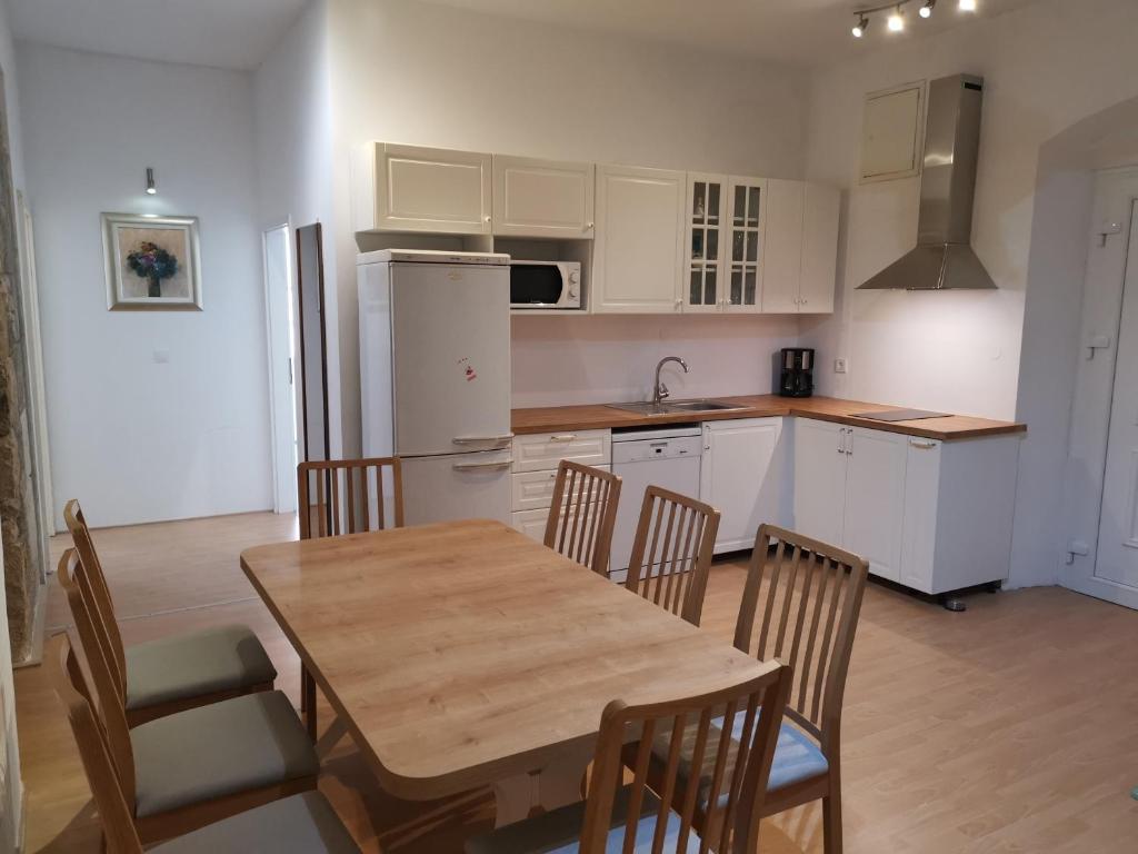 une cuisine avec une table et des chaises et une cuisine avec des placards blancs dans l'établissement Spacious 140m2 Downtown 3 Bedroom Apartment, à Split