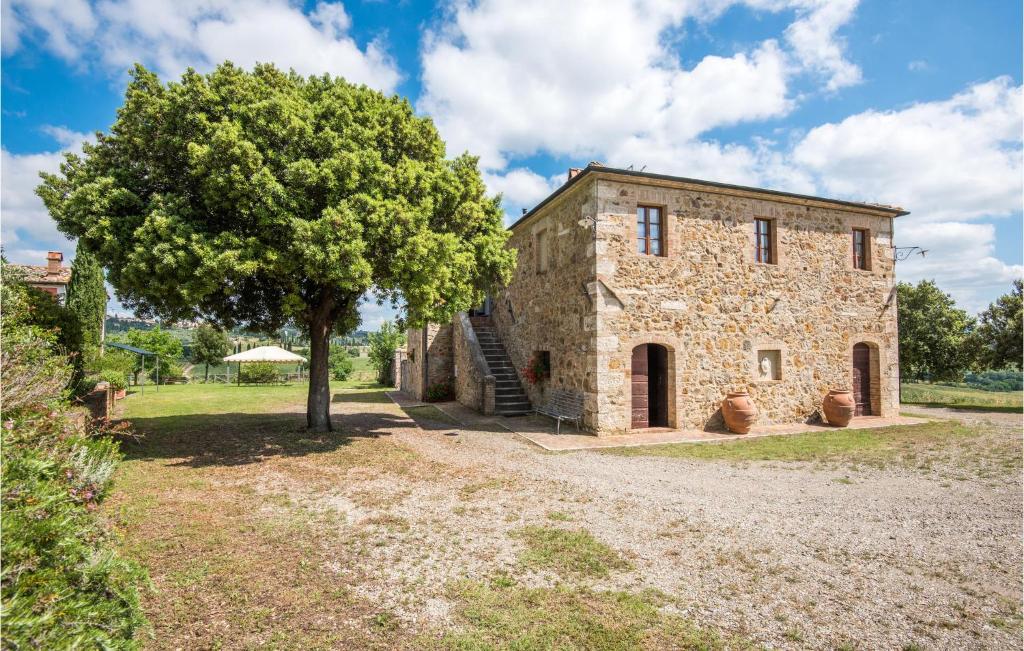 an old stone building with a tree in front of it at Beautiful Home In San Quirico Dorcia With Kitchen in San Quirico dʼOrcia