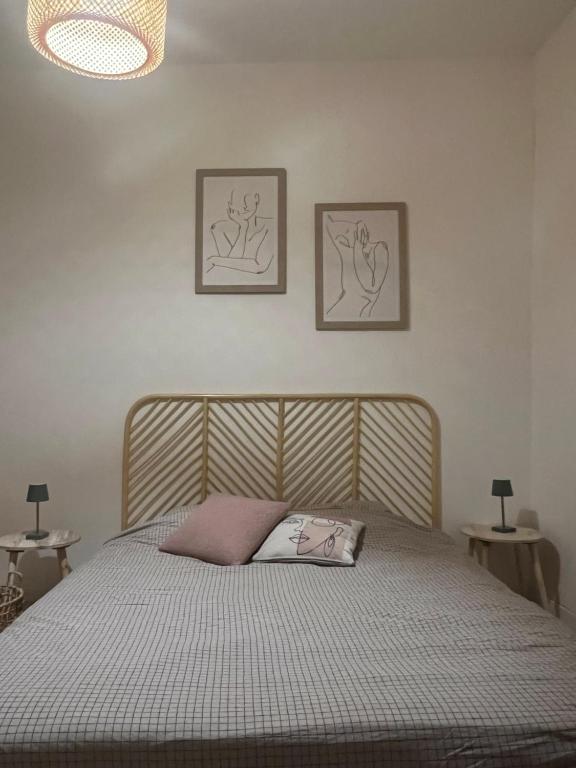 ein Bett in einem Schlafzimmer mit zwei Bildern an der Wand in der Unterkunft Coeur du Vieil Antibes in Antibes