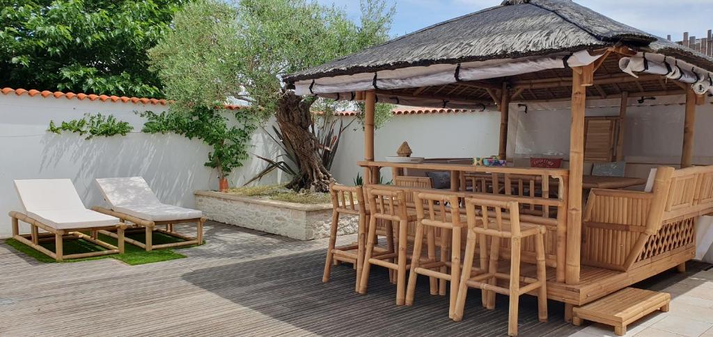 - un kiosque avec un bar et des chaises sur une terrasse dans l'établissement Villa Bahia - ADRIAE Home, à LʼAiguillon-sur-Mer