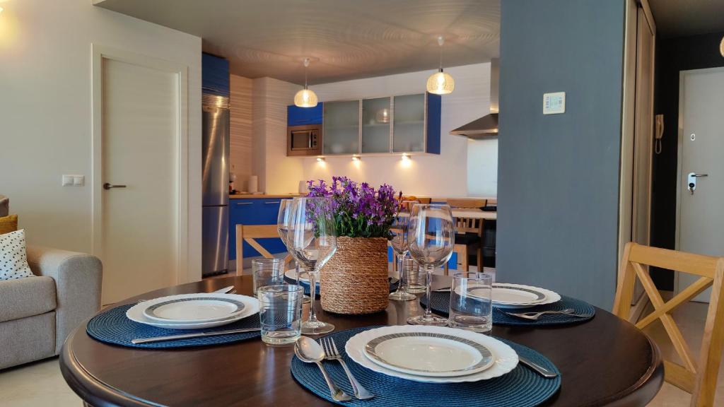 uma mesa de jantar com pratos e copos de vinho em CALA ALTA sunrise apartments em Benidorm
