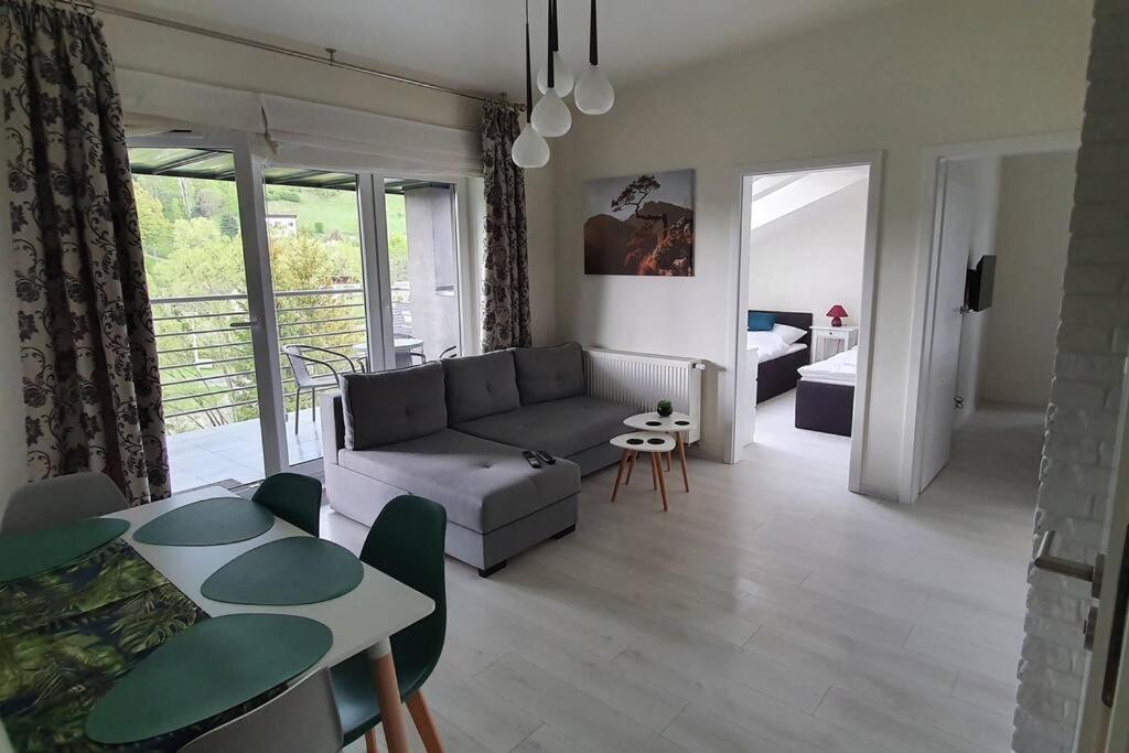 Abstractive Apartament Spokojna في فيسلا: غرفة معيشة مع أريكة وطاولة