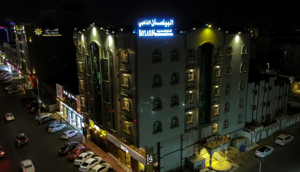 un bâtiment avec un panneau en haut de celui-ci la nuit dans l'établissement البيلسان الذهبي 1, à Djeddah