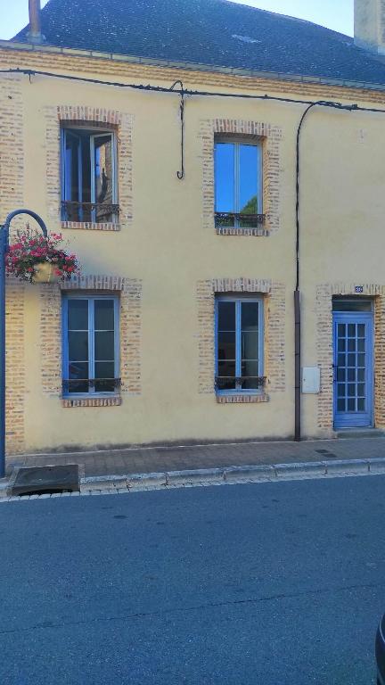 ein Gebäude mit drei Fenstern auf der Straßenseite in der Unterkunft AUBIGNY appartement centre ville 1e étage in Aubigny-sur-Nère