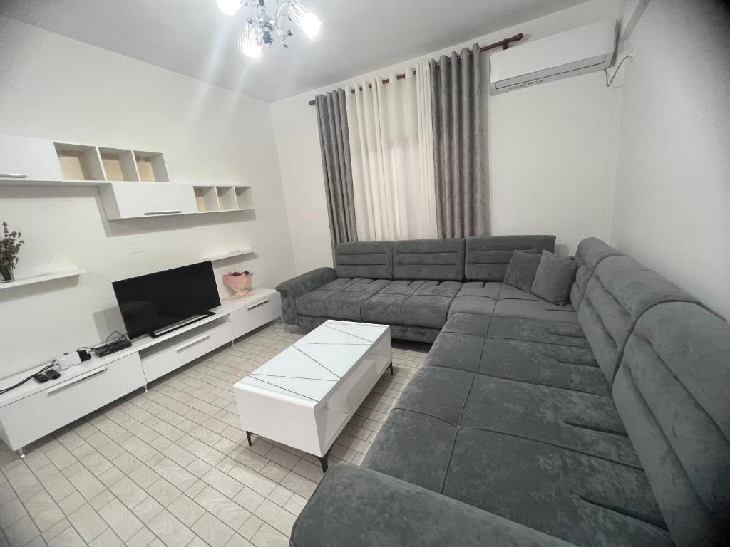 Una sala de estar con un sofá y un televisor. en Vlore , Lungomare, en Vlorë