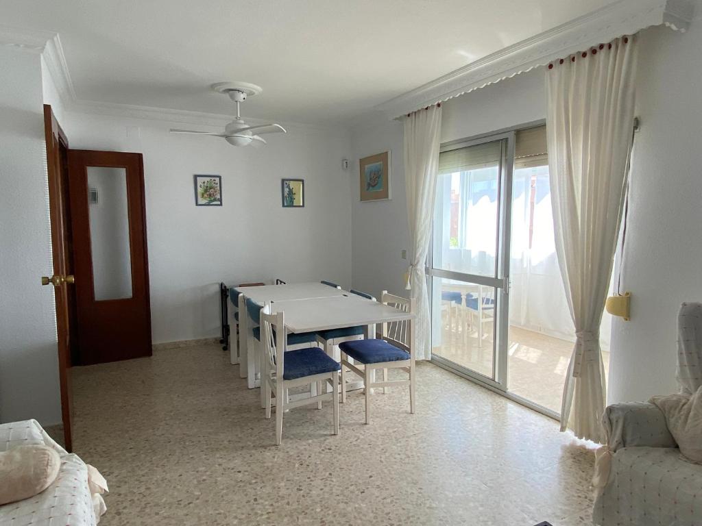 ein Esszimmer mit einem Tisch, Stühlen und einem Fenster in der Unterkunft ESPACIO Y LUZ en Isla Cristina Capacidad hasta 8 HUESPEDES in Isla Cristina