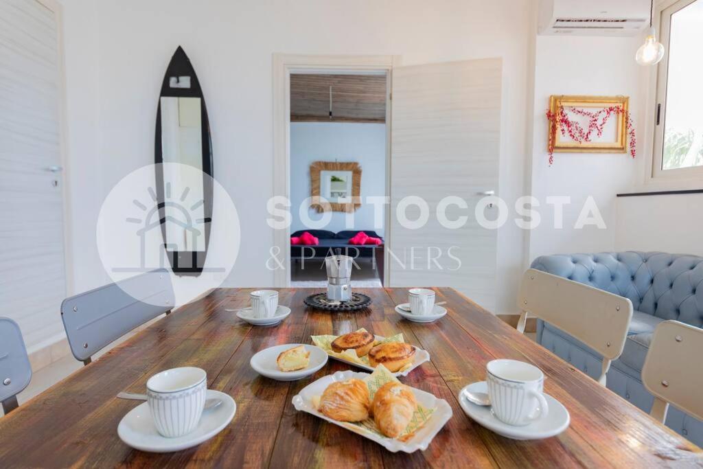 un comedor con una mesa de madera con comida. en Surf Flat, en San Foca
