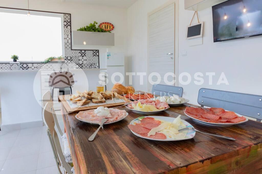 una mesa de madera con platos de comida. en Surf Flat, en San Foca