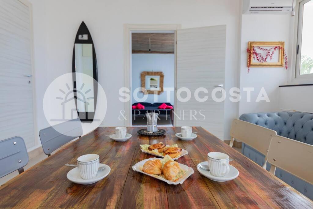 Un comedor con una mesa con croissants y tazas. en Surf Flat, en San Foca