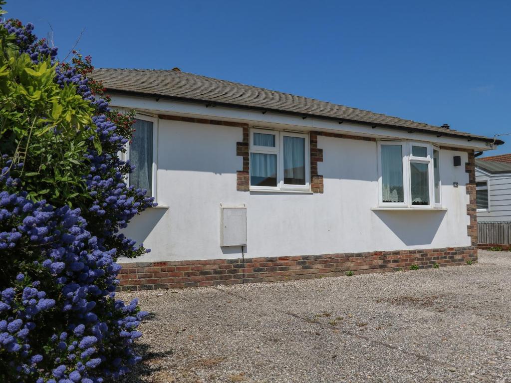 a house with a flowering bush in front of it at 50 Harbour Road in Bognor Regis