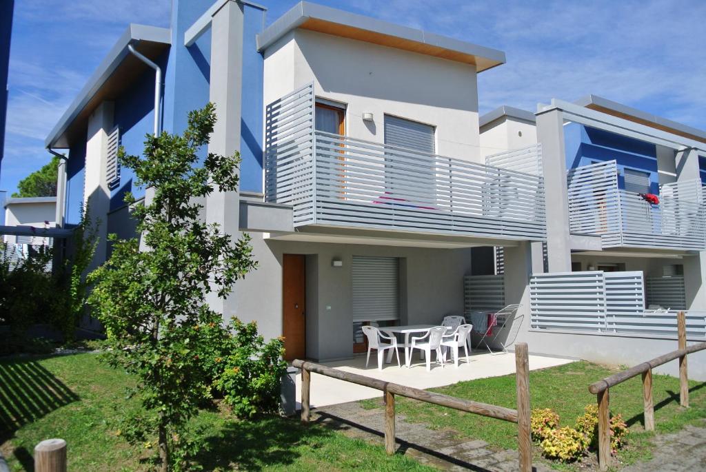 a house with a balcony and a table at Bibione MasterVillage Family in Bibione