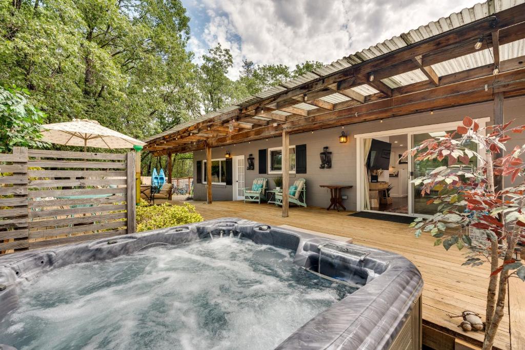 una bañera de hidromasaje en una terraza junto a una casa en Modern Meadow Vista Vacation Home with Spacious Deck, 