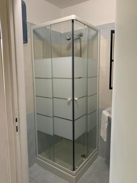 La salle de bains est pourvue d'une porte de douche en verre. dans l'établissement GARIBALDI ROOMS, à Reggio de Calabre